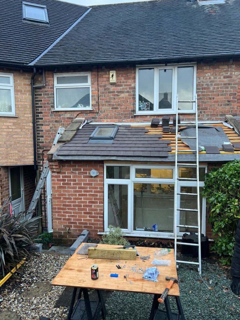 This is a photo of a roof extension that is having new roof tiles installed. This is a photo taken from the roof ridge looking down a tiled pitched roof on to a flat roof. Works carried out by Mansfield Woodhouse Roofing Repairs