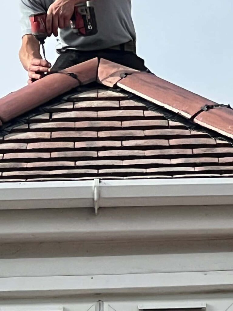 This is a photo of one of the operatives of Mansfield Woodhouse Roofing Repairs installing new ridge tiles